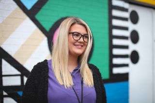 Female staff member in Second Chance uniform, smiling